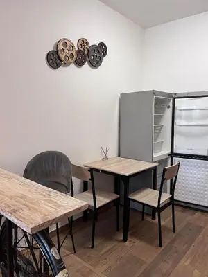 a kitchen with a table and chairs and a refrigerator at Penzion Mánes in Krabčice