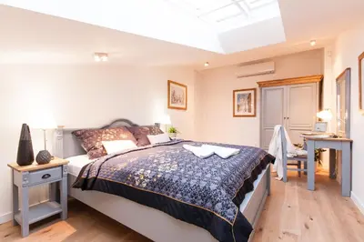 a bedroom with a large bed and a desk at Residence Glamour Excellent in Prague