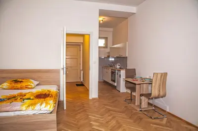 a room with a bed and a table and a kitchen at Beautiful Central Apartment Thámova in Prague