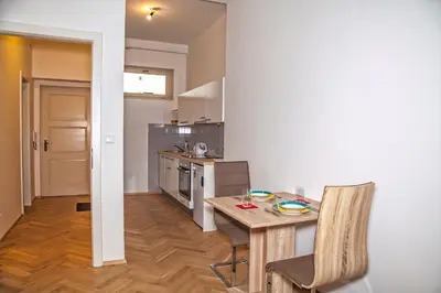 a small kitchen with a wooden table and chairs at Beautiful Central Apartment Thámova in Prague