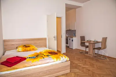 a bedroom with a bed and a table and a kitchen at Beautiful Central Apartment Thámova in Prague