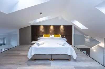 a bedroom with a large bed with yellow pillows at Wishlist Prague Residences - Old Town Square in Prague