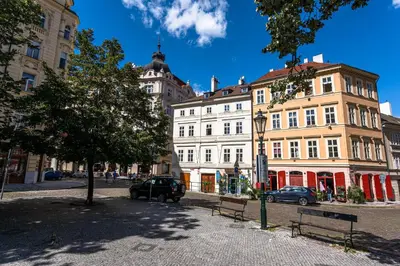 a street in a city with buildings and a tree at Wishlist Prague Residences - Old Town Square in Prague