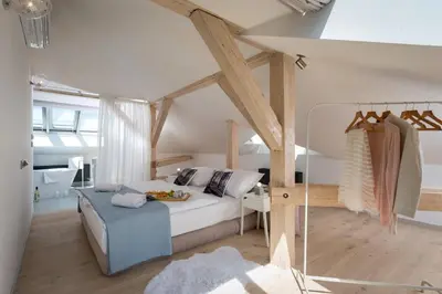 a bedroom with a white bed and a blue couch at Wishlist Prague Residences - Old Town Square in Prague