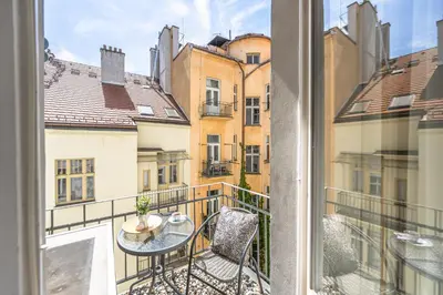 a balcony with a table and chairs and buildings at Wishlist Prague Residences - Old Town Bilkova in Prague