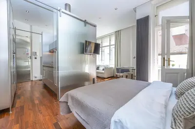a bedroom with a bed and a glass wall at Wishlist Prague Residences - Old Town Bilkova in Prague