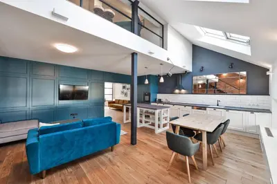 a living room with a blue couch and a table at Wishlist Prague Residences - Charles Bridge in Prague