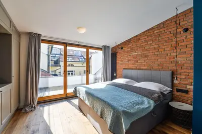 a bedroom with a brick wall and a bed at Wishlist Prague Residences - Charles Bridge in Prague