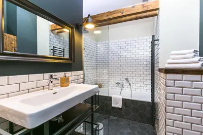 a bathroom with a white sink and a shower at Wishlist Prague Residences - Charles Bridge in Prague