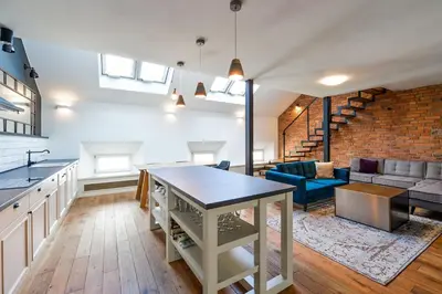 a kitchen and living room with a brick wall at Wishlist Prague Residences - Charles Bridge in Prague