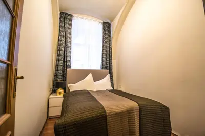 a small room with a bed and a window at 4BDR Historical Spirit Apt by Ruterra in Prague