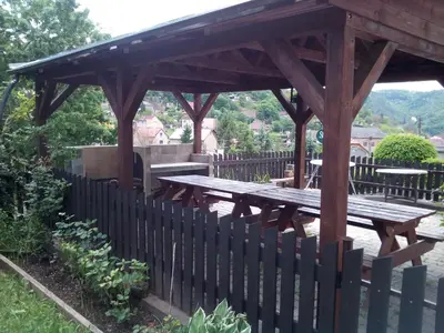 a wooden gazebo with a wooden picnic table at Penzion Lida in Srbsko