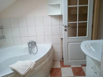 a white bathroom with a tub and a sink at Penzion Lida in Srbsko