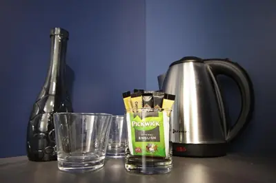 a table with a kettle and two glasses and a bottle at Alveo Suites in Prague