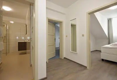 a room with a bathroom and a bed and a mirror at Alveo Suites in Prague