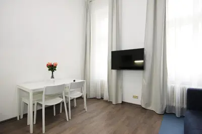 a white dining room with a white table and chairs at Alveo Suites in Prague