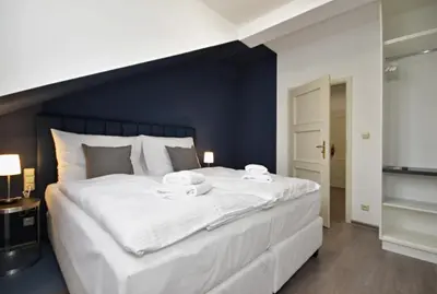 a large white bed with two white dishes on it at Alveo Suites in Prague