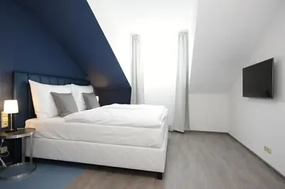 a bedroom with a white bed with a blue ceiling at Alveo Suites in Prague
