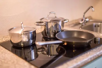 two pots and pans sitting on top of a stove at Duskova Apartments in Prague
