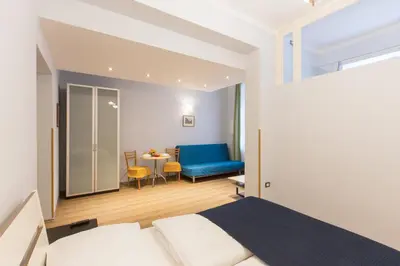 a bedroom with a bed and a couch and a table at Duskova Apartments in Prague