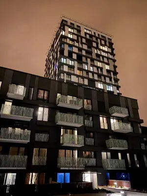 a tall building with many windows at night at Apartment David Garden Towers in Prague