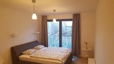 a bedroom with a bed in front of a window at Apartment David Garden Towers in Prague
