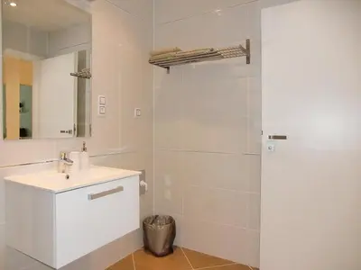 a white bathroom with a sink and a mirror at Apartment David Garden Towers in Prague