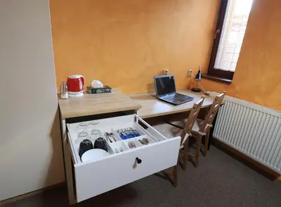 a hotel room with a bed and a desk with a laptop at U Admirala in Kladno