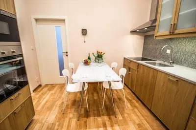 a kitchen with a table with chairs and a sink at Bourgeois Apartment in Cultural Heritage Building by Ruterra in Prague