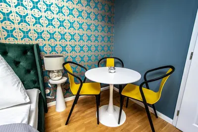 a table and chairs in a room with a bed at Bourgeois Apartment in Cultural Heritage Building by Ruterra in Prague