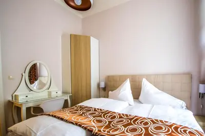 a bedroom with a large bed and a mirror at Bourgeois Apartment in Cultural Heritage Building by Ruterra in Prague