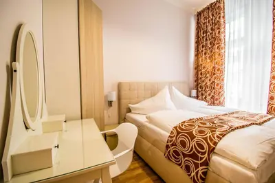 a hotel room with a bed and a dressing table at Bourgeois Apartment in Cultural Heritage Building by Ruterra in Prague