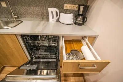 a kitchen counter with a dishwasher under a counter at Bourgeois Apartment in Cultural Heritage Building by Ruterra in Prague