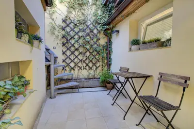a patio with two tables and a wall with plants at Agnes - Apartments in Prague