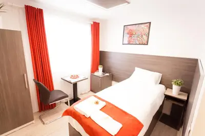 a hotel room with a bed and a desk and a chair at Villa Royal in Prague