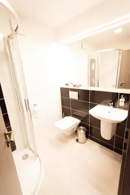 a bathroom with a toilet and a sink and a shower at Villa Royal in Prague