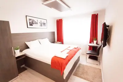 a bedroom with a bed with a red blanket at Villa Royal in Prague
