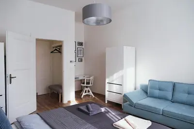 a living room with a blue couch and a desk at Apartment Gesse Jirsikova in Prague