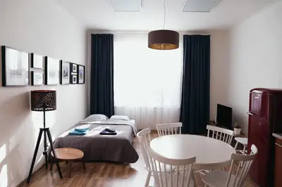 a bedroom with a bed and a table and chairs at Apartment Gesse Jirsikova in Prague
