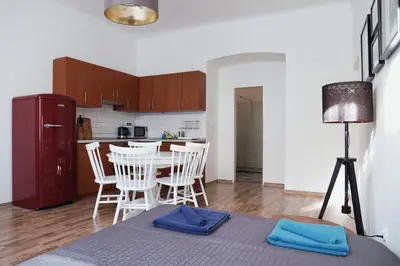 a kitchen and dining room with a table and chairs at Apartment Gesse Jirsikova in Prague