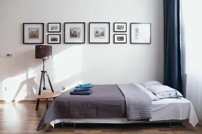 a bedroom with a bed and framed pictures on the wall at Apartment Gesse Jirsikova in Prague
