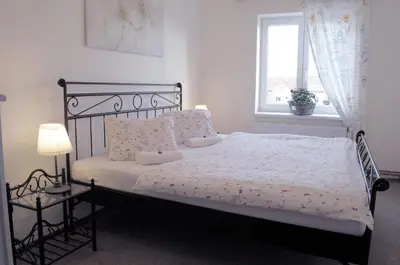 a bedroom with a bed with a black frame and a window at Apartmány V Podzámčí II. in Mělník