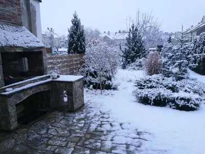a garden covered in snow with a stone bench at Apartmány V Podzámčí II. in Mělník