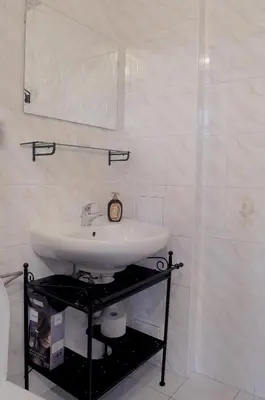 a white bathroom with a sink and a mirror at Apartmány V Podzámčí II. in Mělník