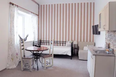 a kitchen with a table and a bedroom with a bed at Apartmány V Podzámčí II. in Mělník