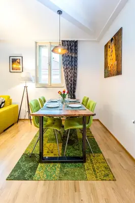 a dining room with a table and green chairs at Baranova Apartments in Prague