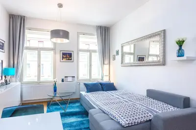 a living room with a couch and a mirror at Baranova Apartments in Prague