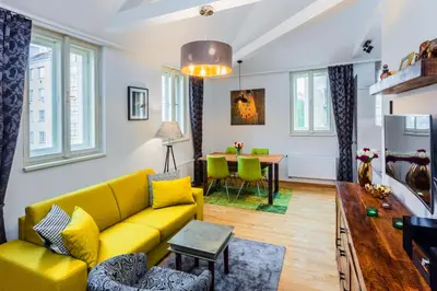 a living room with a yellow couch and a table at Baranova Apartments in Prague