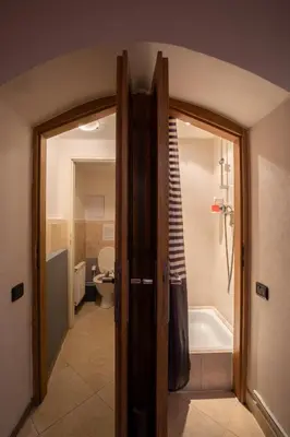 a bathroom with a door open to a tub and a toilet at Party Underground with Pooltable in Prague