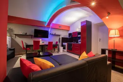 a living room with a couch and a dining room at Party Underground with Pooltable in Prague